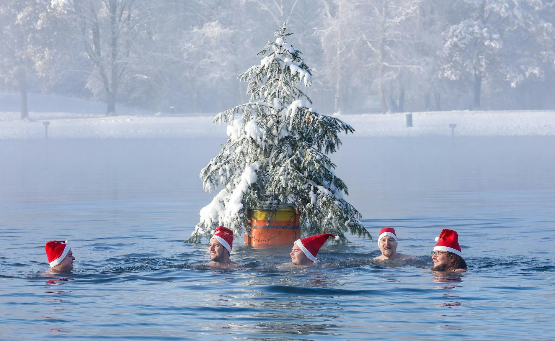 dpatopbilder - Männer mit Nikolausmützen schwimmen bei Minusgraden im Schwarzachtalsee.