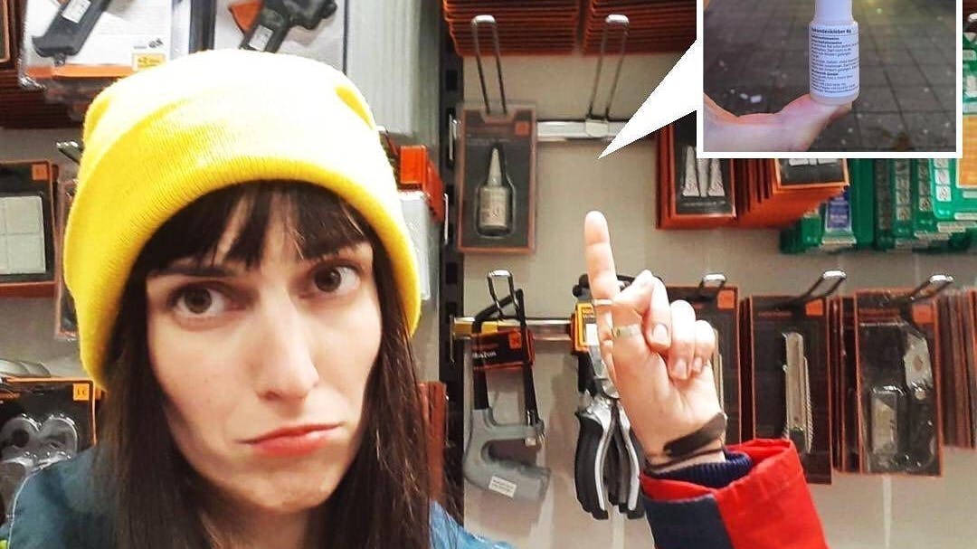 Klima-Aktivistin Alfa zeigt auf das Regal in einer Filiale, wo es den Sekundenkleber nicht mehr geben soll.