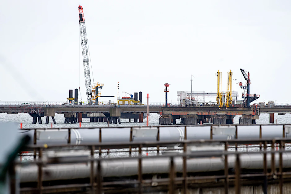 Rohre einer Pipeline führen auf einer Baustelle hinter dem Deich zur Anbindung des LNG-Terminals in Wilhelmshaven.