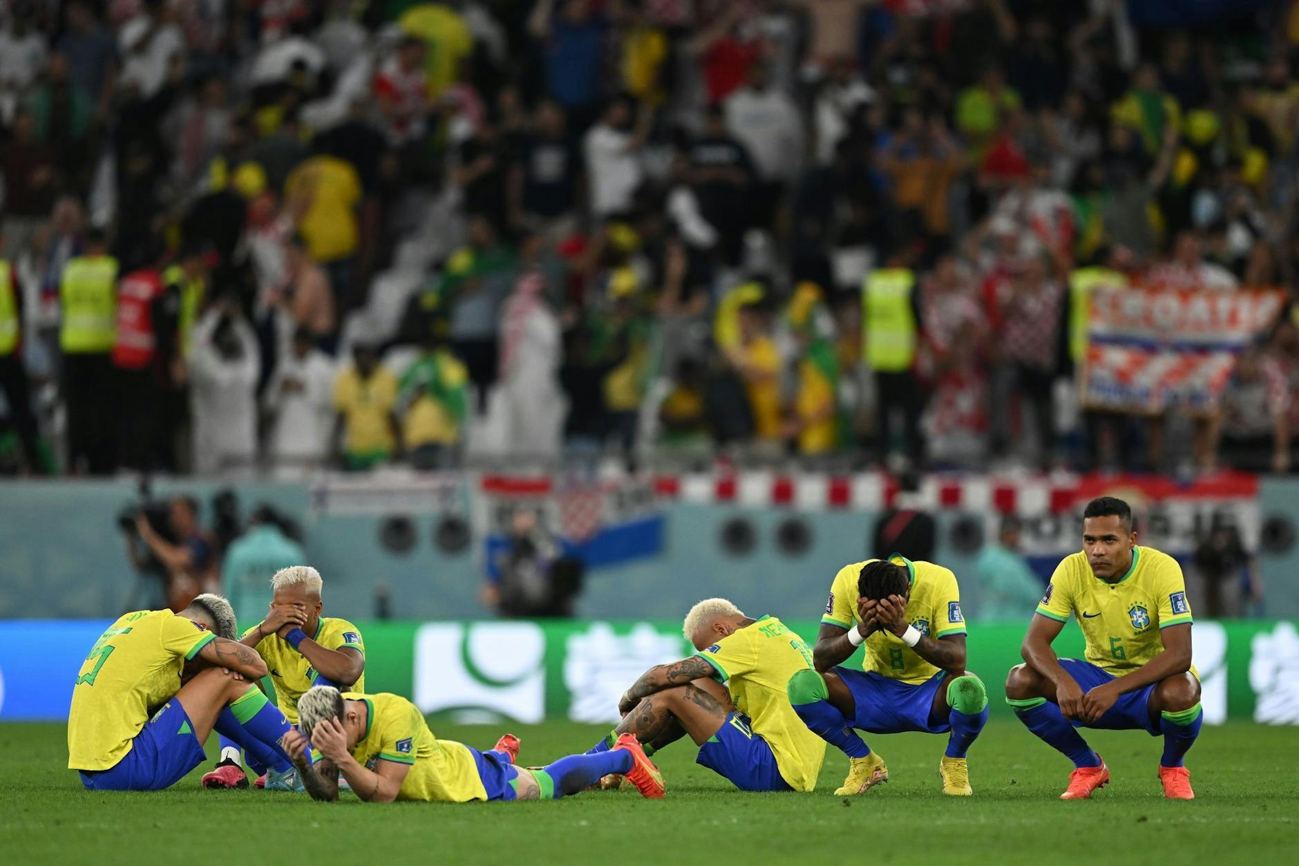 Die Brasilianer sitzen nach der Niederlage enttäuscht auf dem Rasen.