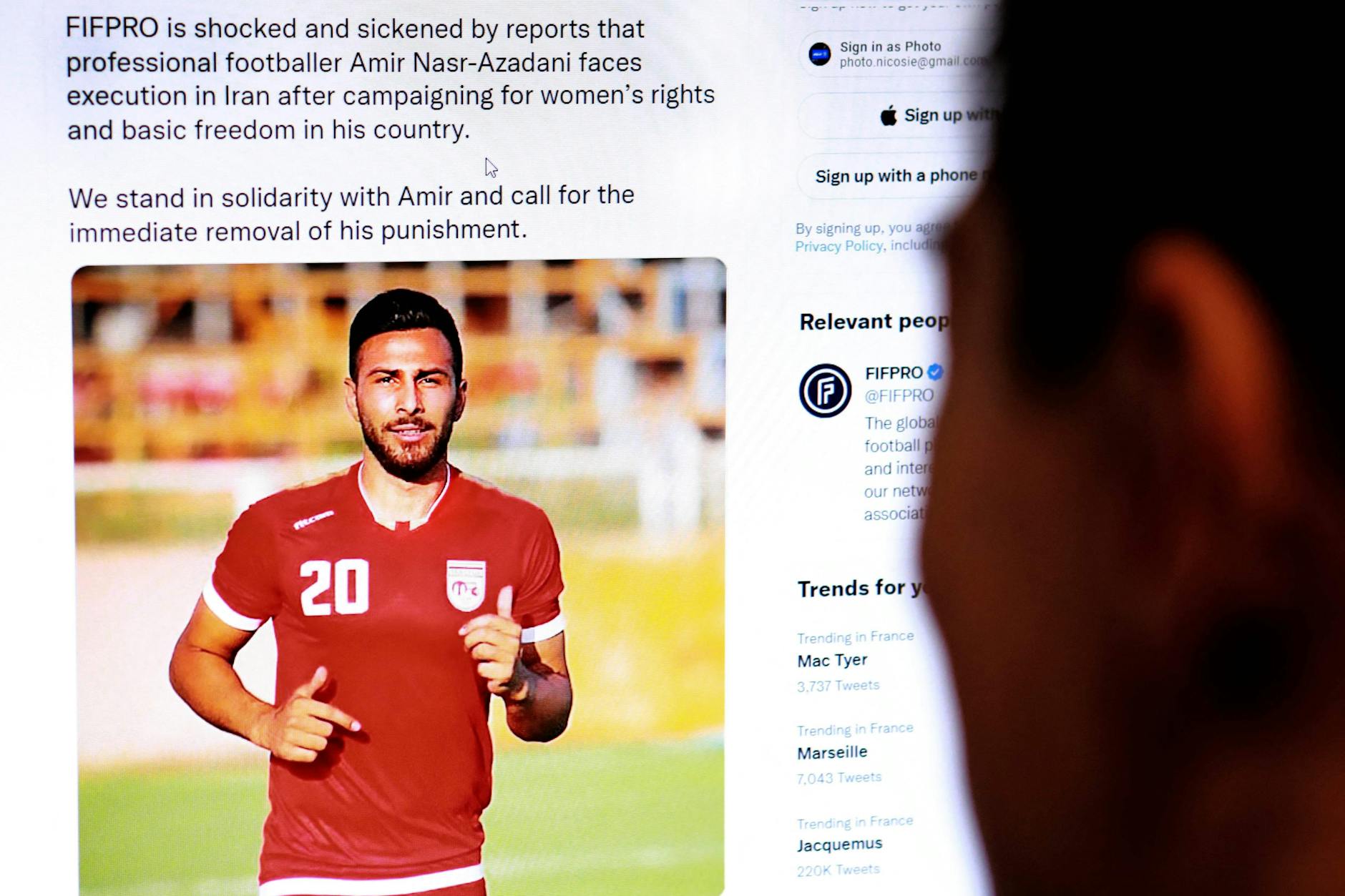 Ein Mann schaut sich den Tweet der Internationalen Föderation der Profifußballer (FIFPro) an, in dem es heißt, dass der iranische Fußballer Amir Nasr-Azadani zum Tode verurteilt wurde.