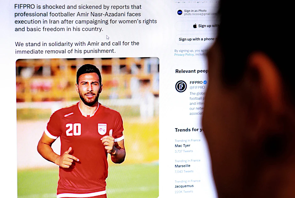 Ein Mann schaut sich den Tweet der Internationalen Föderation der Profifußballer (FIFPro) an, in dem es heißt, dass der iranische Fußballer Amir Nasr-Azadani zum Tode verurteilt wurde.