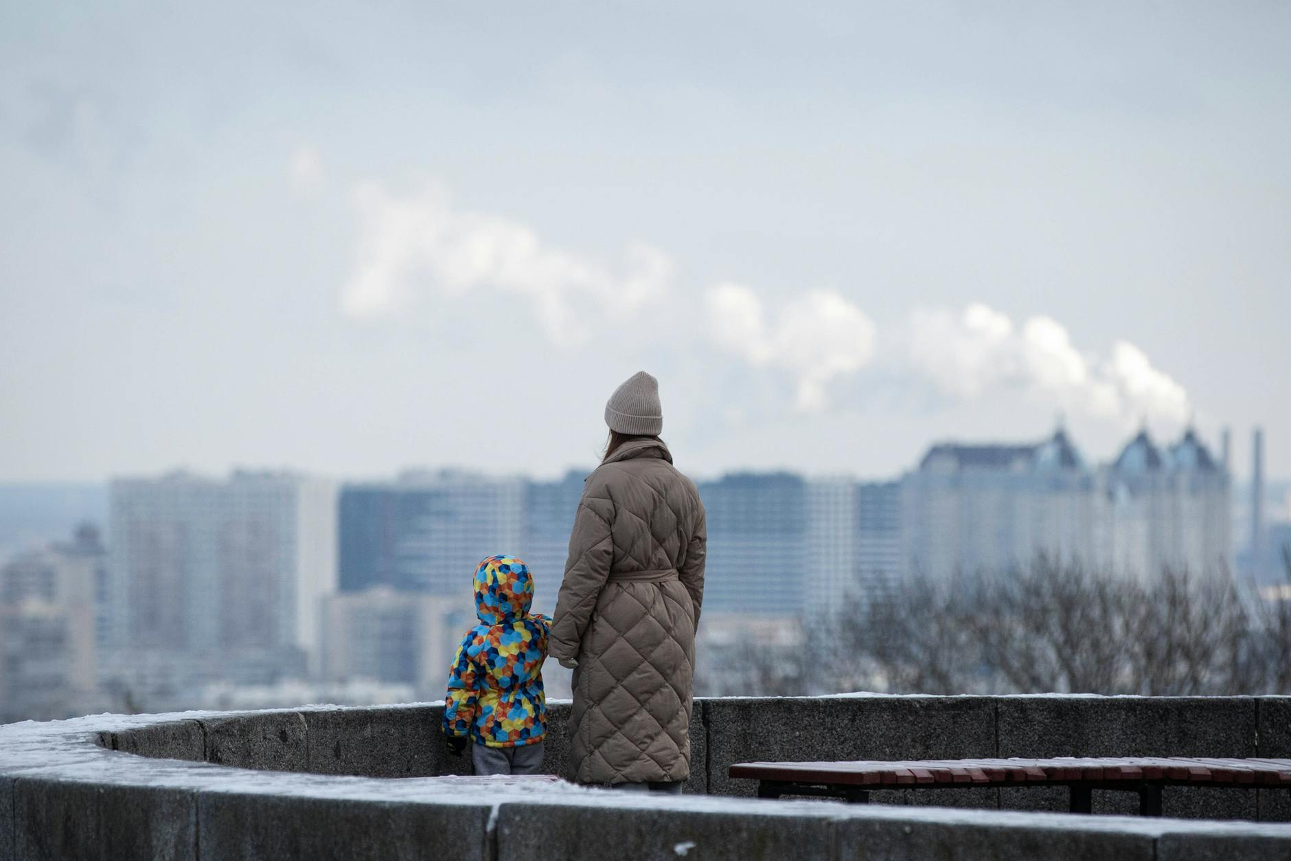 Eine Frau und ein Kind blicken auf die Stadt Kiew.