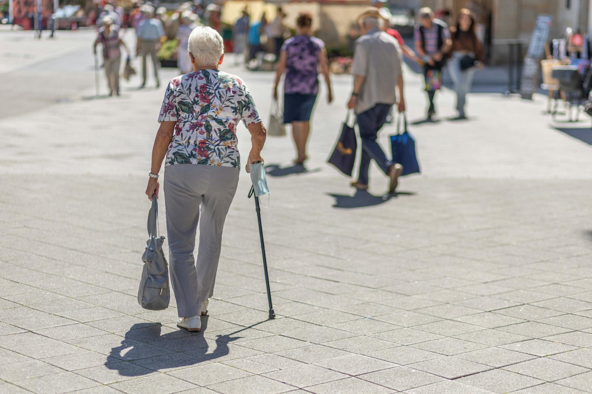 Berlin: Eine ältere Dame läuft mit Gehhilfe auf dem Gehweg. Einer Studie zufolge werden Ältere in der Corona-Pandemie zunehmend einsamer. Das hat fatale Folgen.