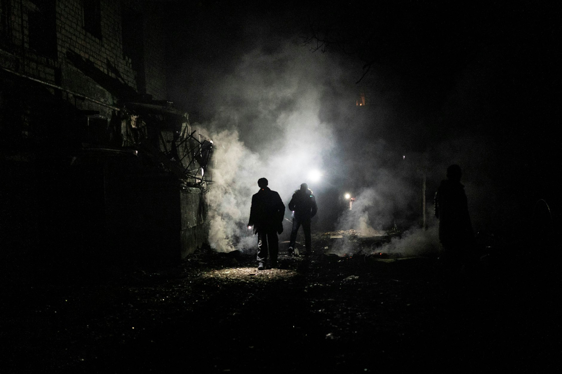  Anwohner gehen in Cherson nach einem russischen Angriff durch die Trümmer.