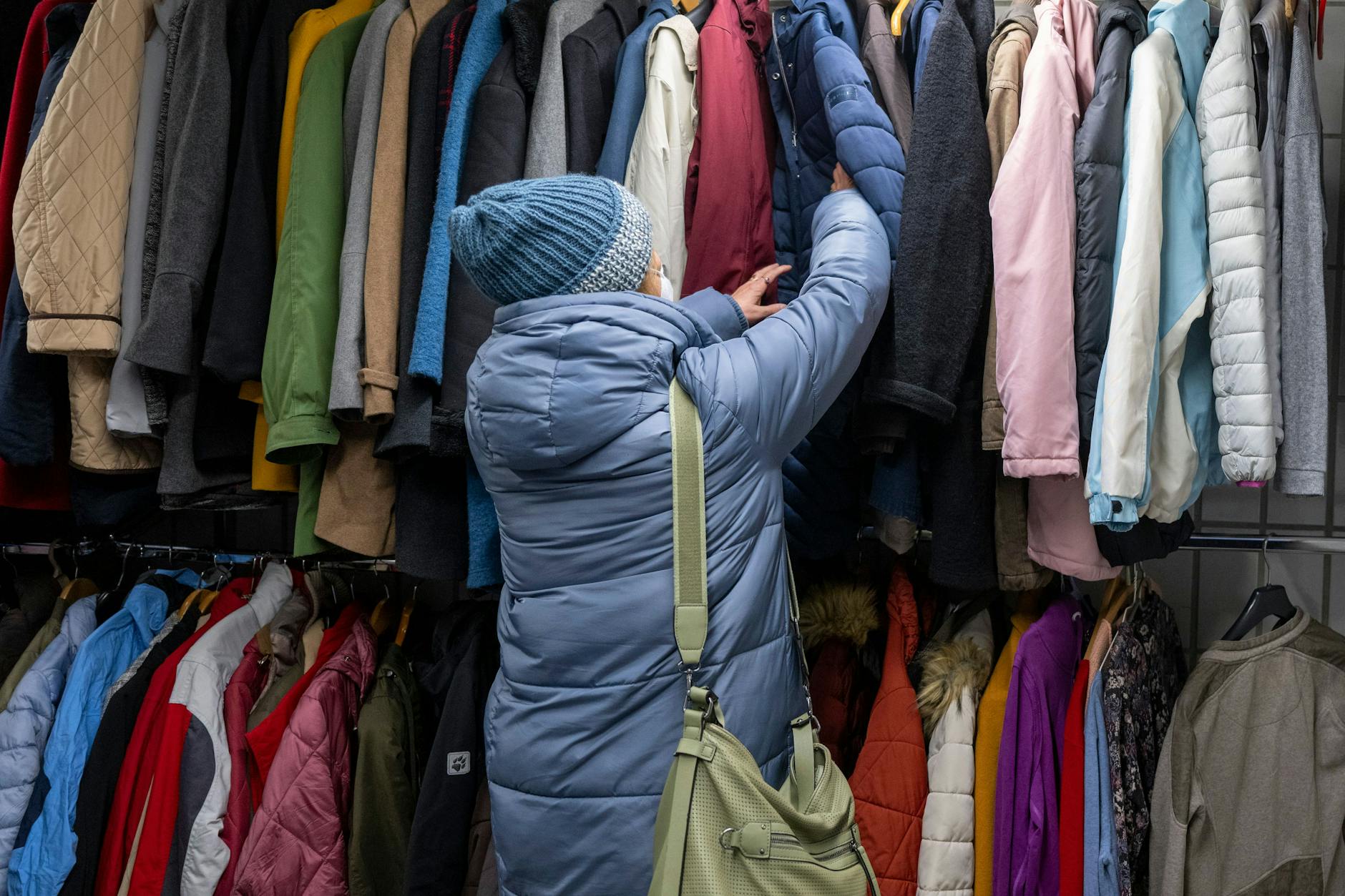 Berlin im Winter 2022: Eine Frau sucht in der Kleiderkammer der Berliner Stadtmission nach einer warmen Winterjacke.