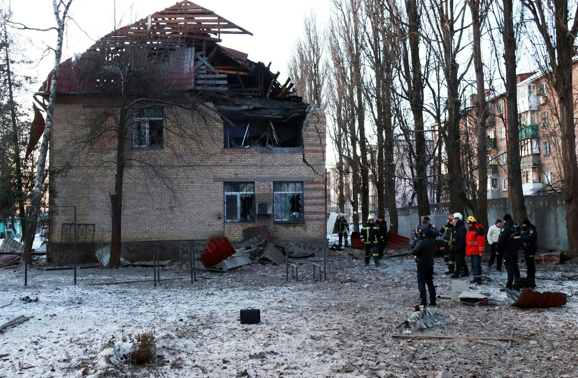 Rettungskräfte stehen in der Nähe eines beschädigten Gebäudes in Kiew.