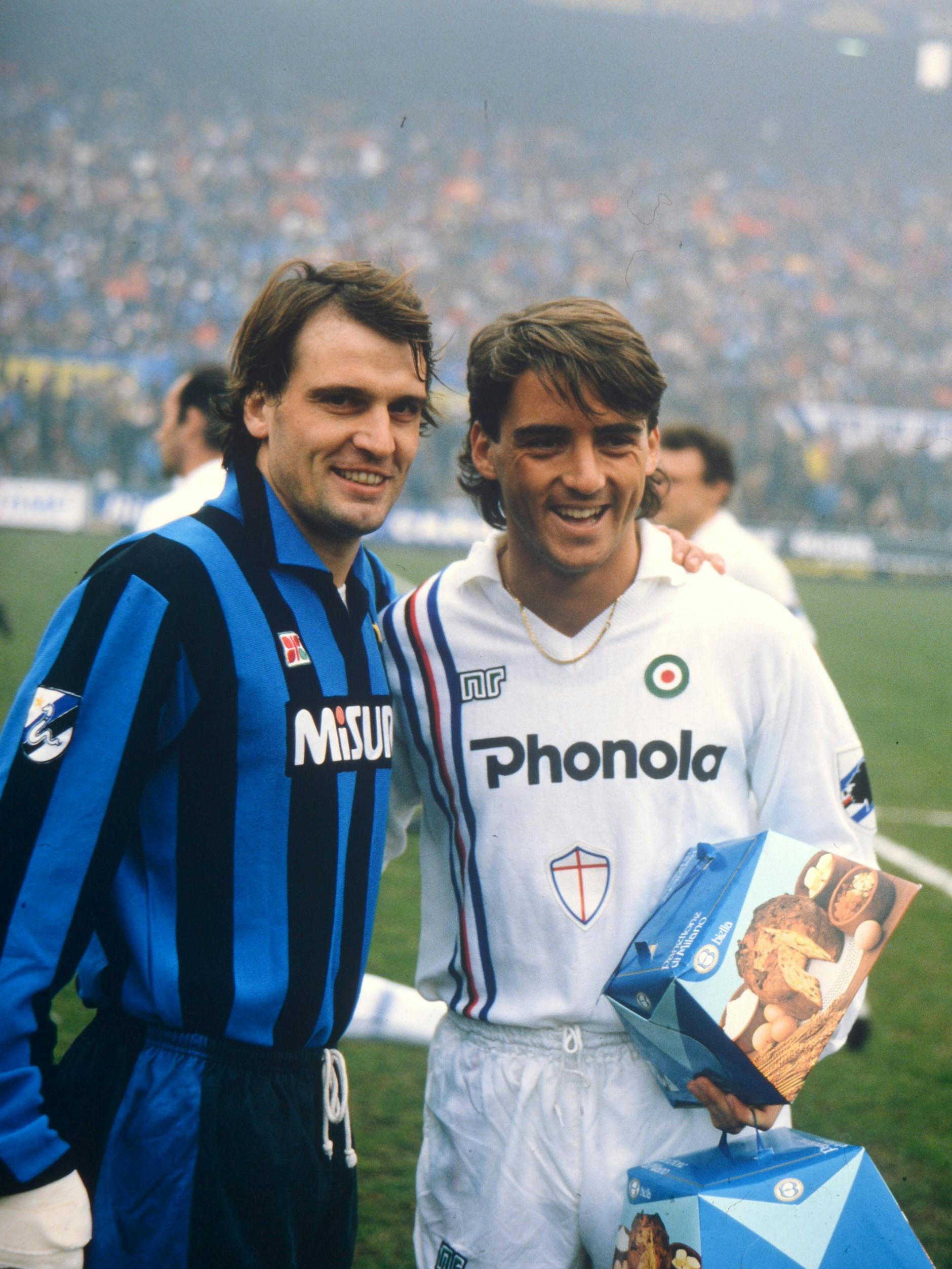 Der ehemalige Fußballer Roberto Mancini (l.) bekommt einen Panettone geschenkt. Ob das Lächeln nur gespielt ist? Wir denken, ja, denn so ein Kuchen schmeckt scheußlich!