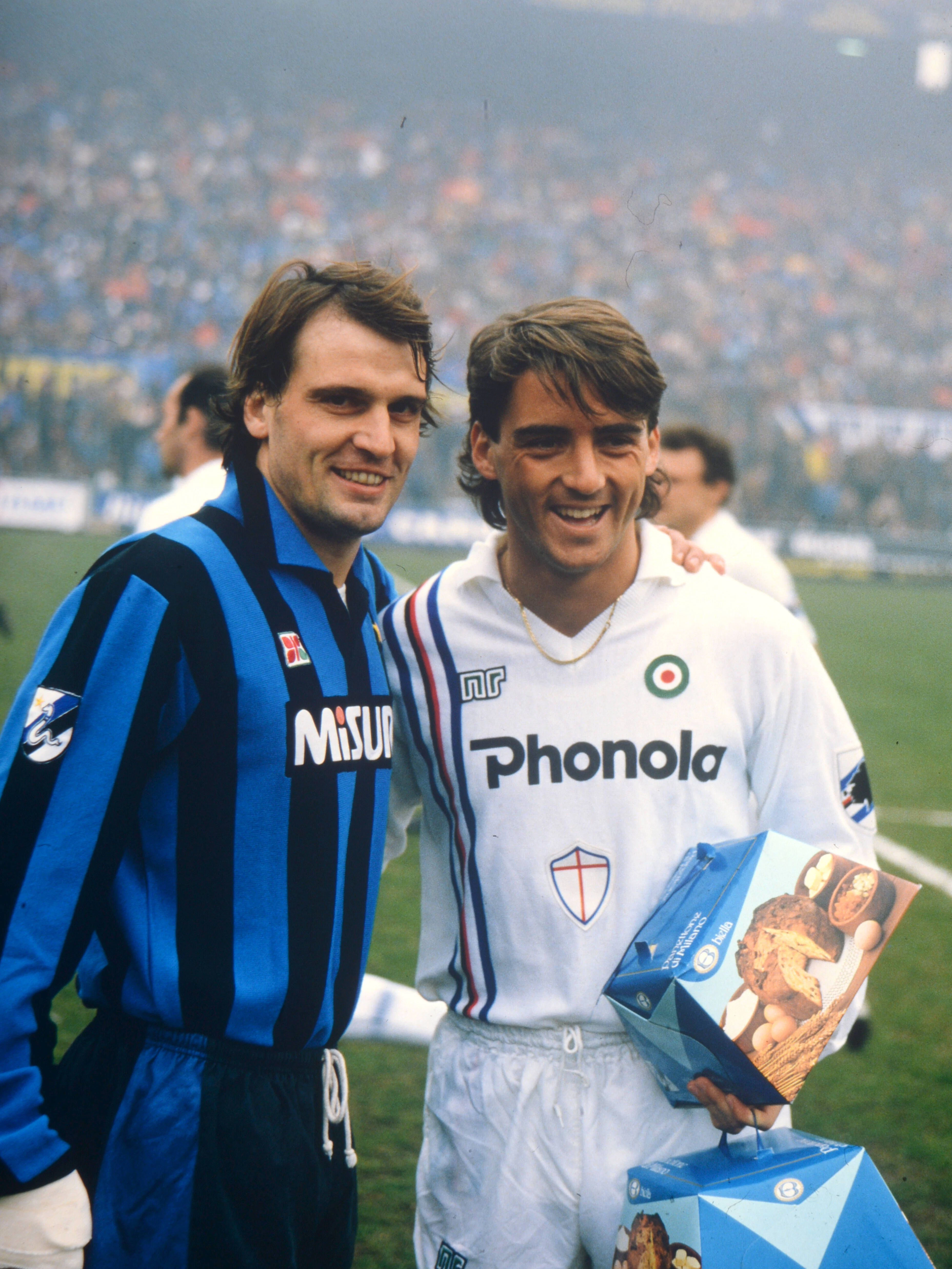 Der ehemalige Fußballer Roberto Mancini (l.) bekommt einen Panettone geschenkt. Ob das Lächeln nur gespielt ist? Wir denken, ja, denn so ein Kuchen schmeckt scheußlich!