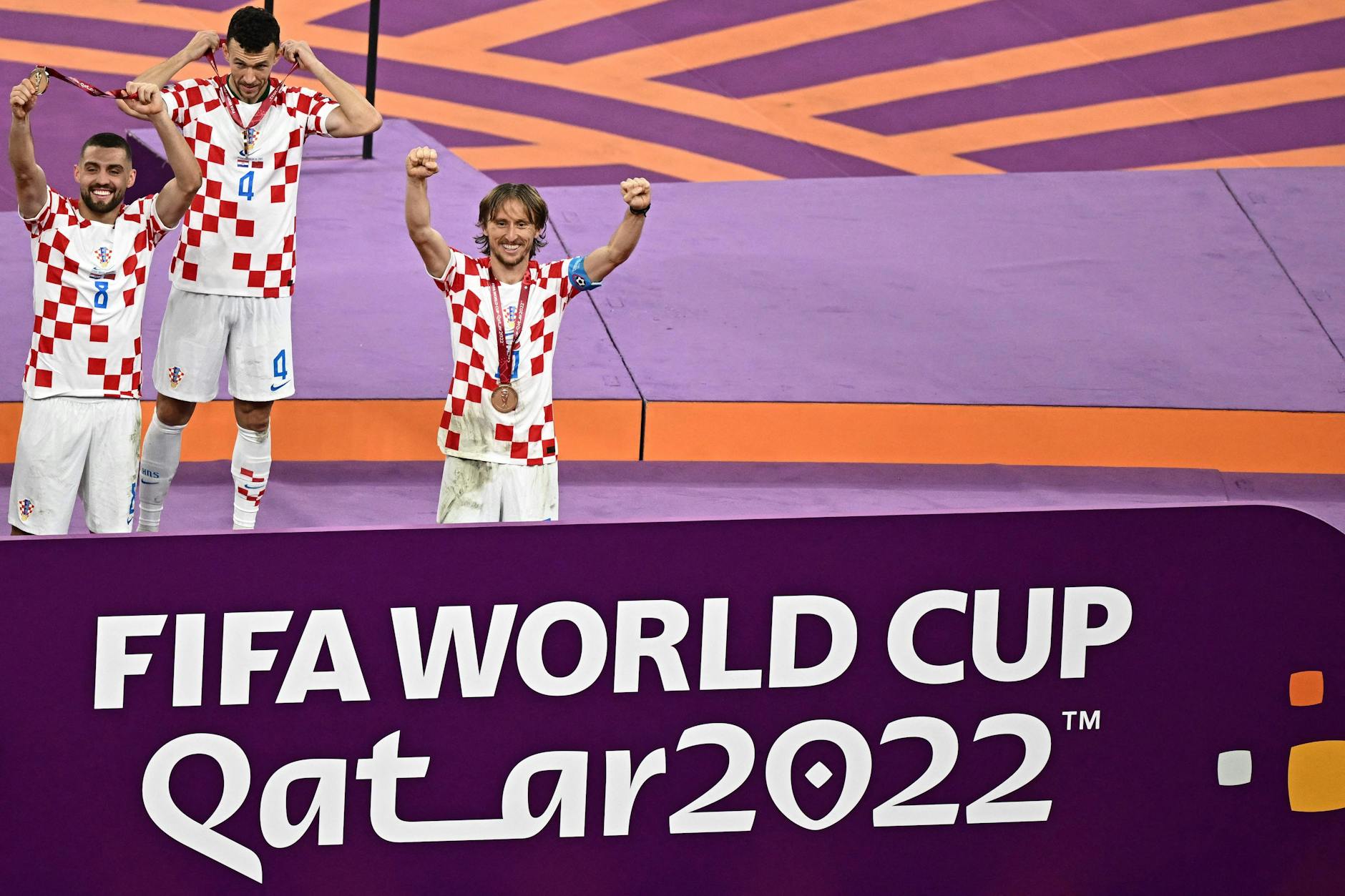 Von links: Der kroatische Mittelfeldspieler (Nr. 08) Mateo Kovacic, der kroatische Mittelfeldspieler (Nr. 04) Ivan Perisic und der kroatische Mittelfeldspieler (Nr. 10) Luka Modric feiern mit Medaillen nach dem Sieg im Spiel um den dritten Platz bei der Fußball-Weltmeisterschaft Katar 2022 zwischen Kroatien und Marokko im Khalifa International Stadium in Doha am 17. Dezember 2022.
