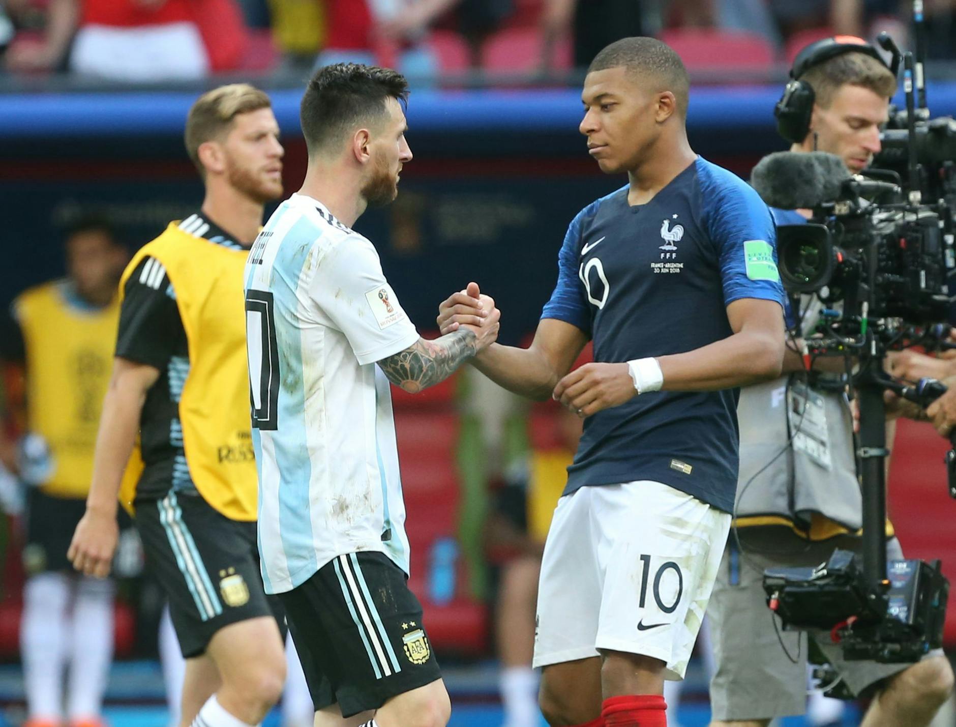ARCHIV - Lionel Messi (l) und Kylian Mbappe geben sich nach dem Spiel bei der WM 2018 die Hand.