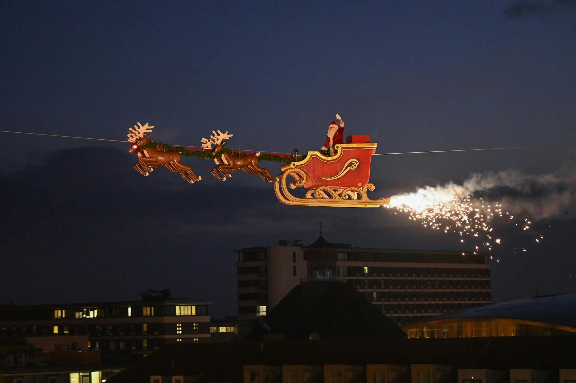 In Kassel fliegt der Weihnachtsmann funkensprühend über den Märchenweihnachtsmarkt hinweg. 