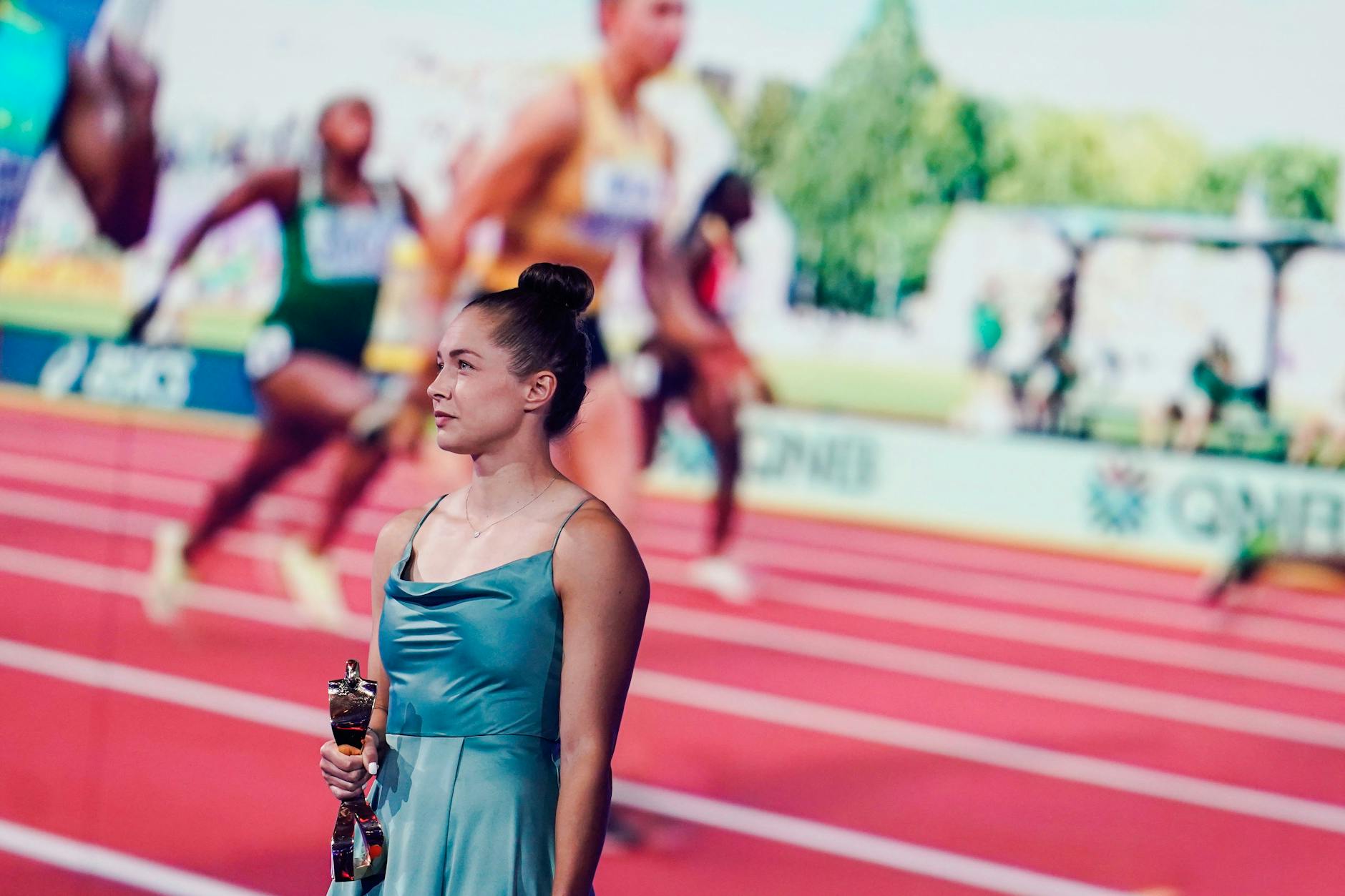 Sprinterin Gina Lückenkemper schaut bei der Sportler-des-Jahres-Gala in Baden-Baden sich selbst beim Rennen zu.