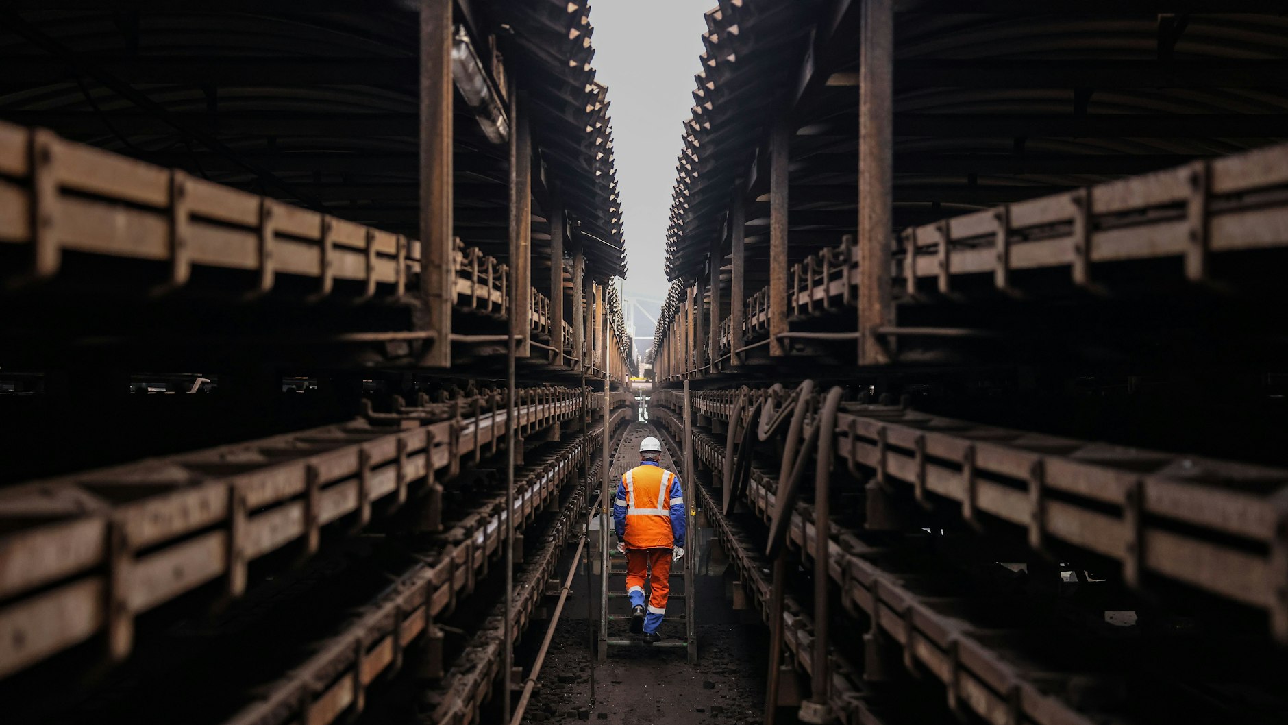 Ein Mitarbeiter geht zwischen den Förderbändern der Brikettfabrik Wachtberg in Frechen hindurch.