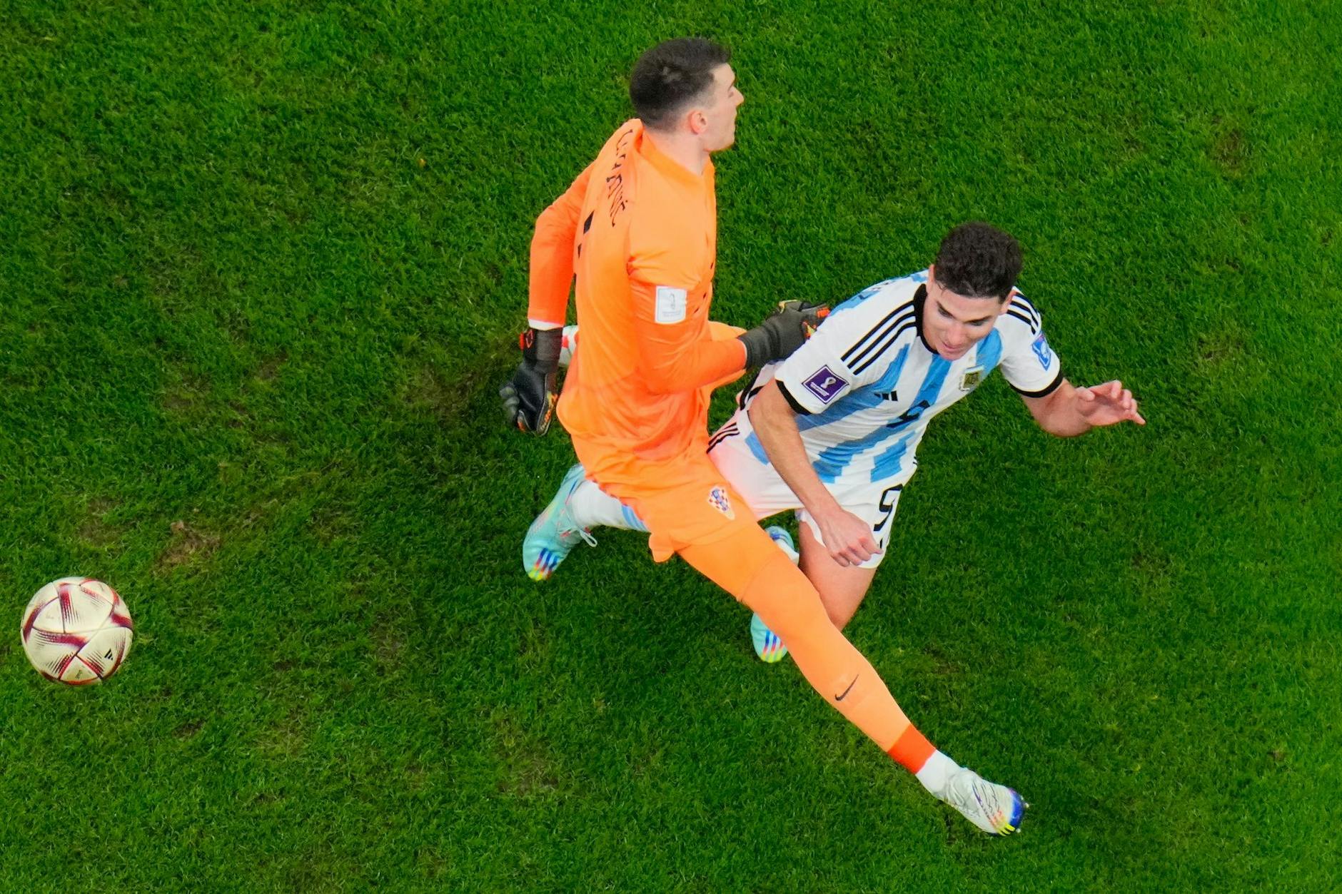 Kroatiens Torhüter Dominik Livakovic (l) foult im Strafraum den Argentinier Julian Alvarez.