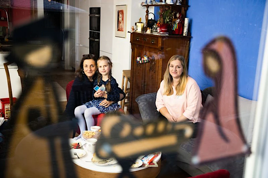 Die sechsjährige Yeva aus der Ukraine spielt mit ihrer Mutter Yuliia (r.) und ihrer Gastgeberin Rosemarie im Wohnzimmer Karten.