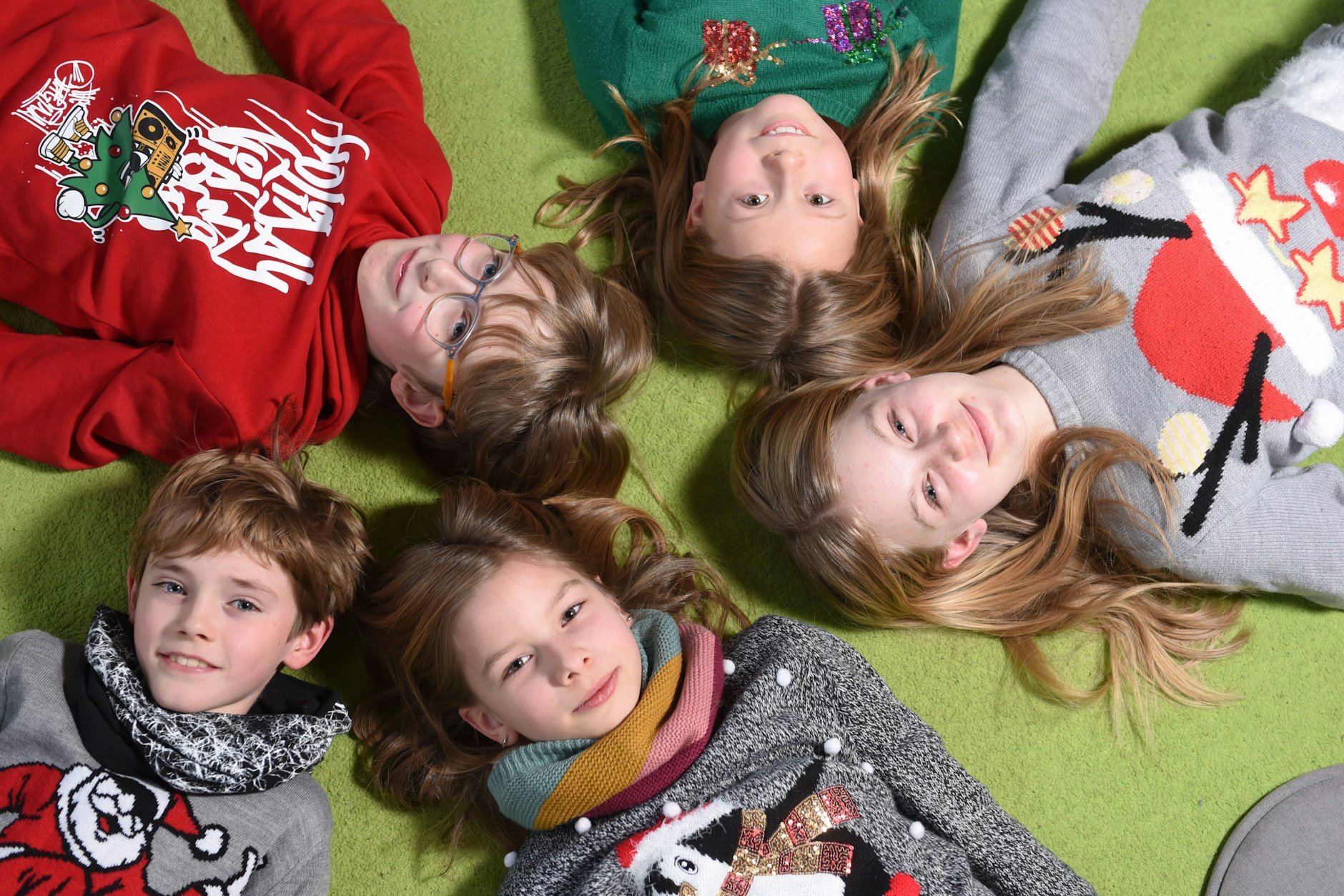 Fünf aus Friedrichshain: Emi trägt einen grünen Pullover, links von ihr liegt Roman, dann Joshua, Elli und Nehalennia.