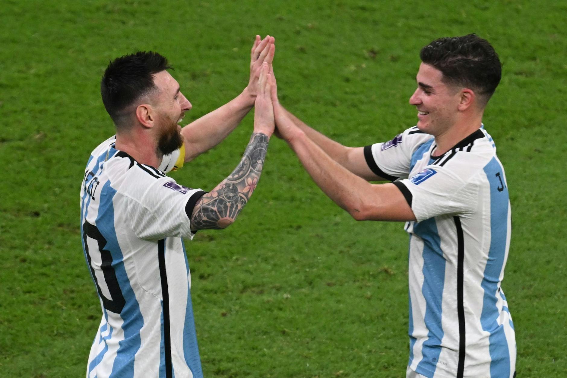 Argentiniens Torschütze Julian Alvarez (r) jubelt nach dem 3:0 mit Vorlagengeber Lionel Messi.