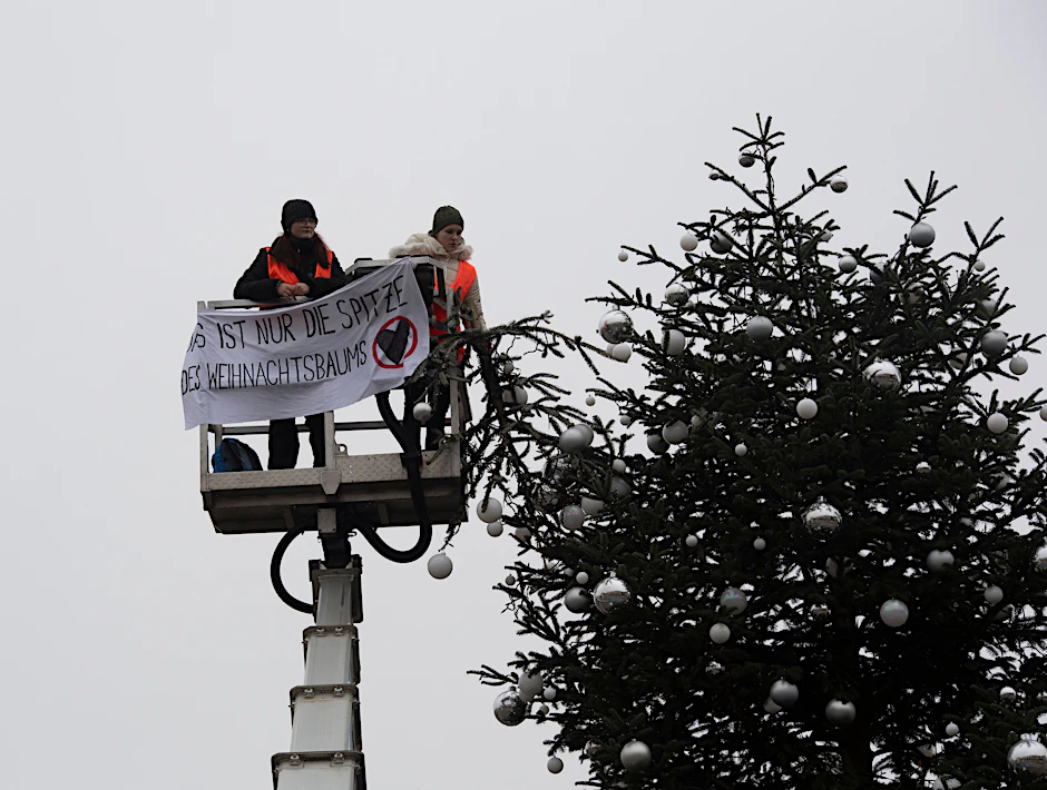 Klima-Aktivisten sägen die Spitze des Weihnachtsbaumes am Brandenburger Tor ab - und die Polizei vor Ort greift nicht ein.