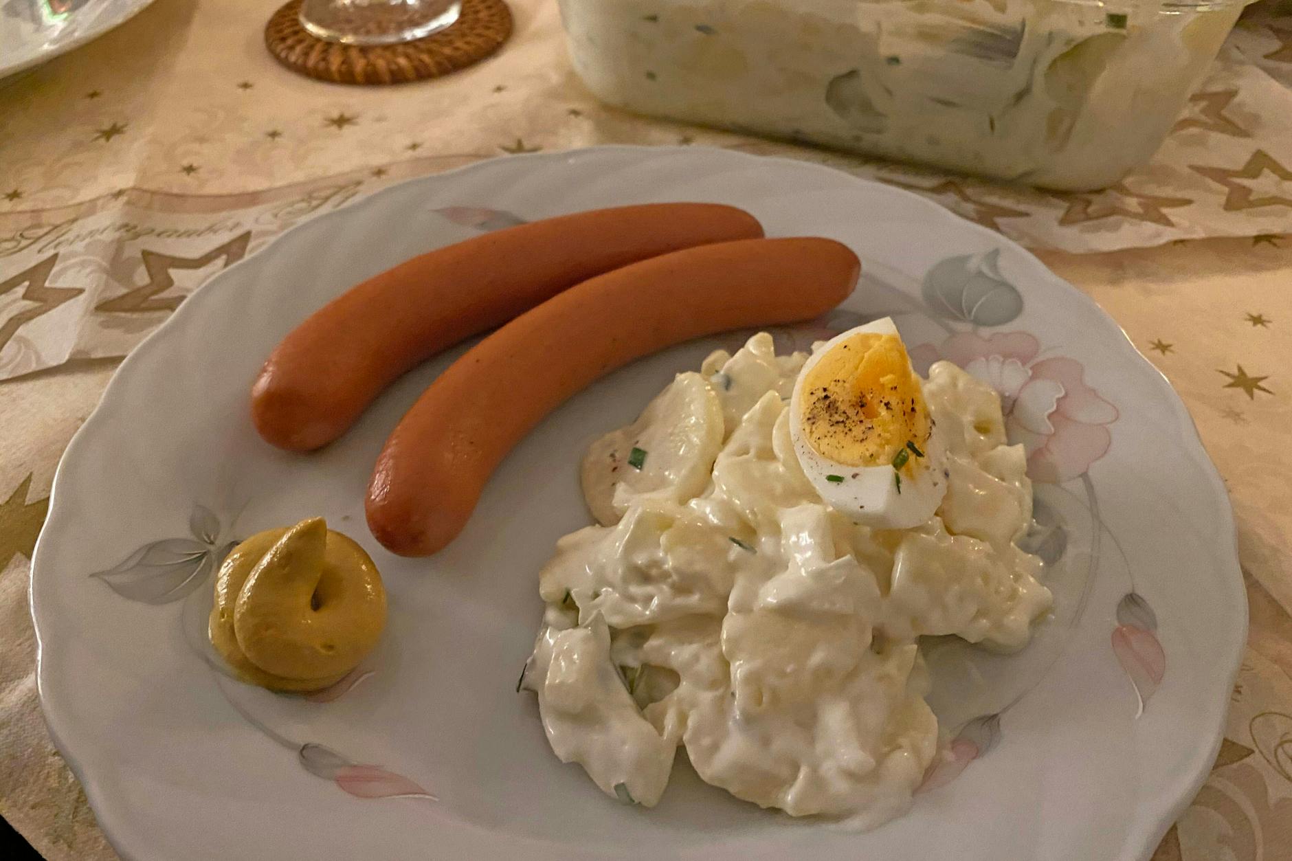 Kartoffelsalat mit Würstchen auf einem Teller.