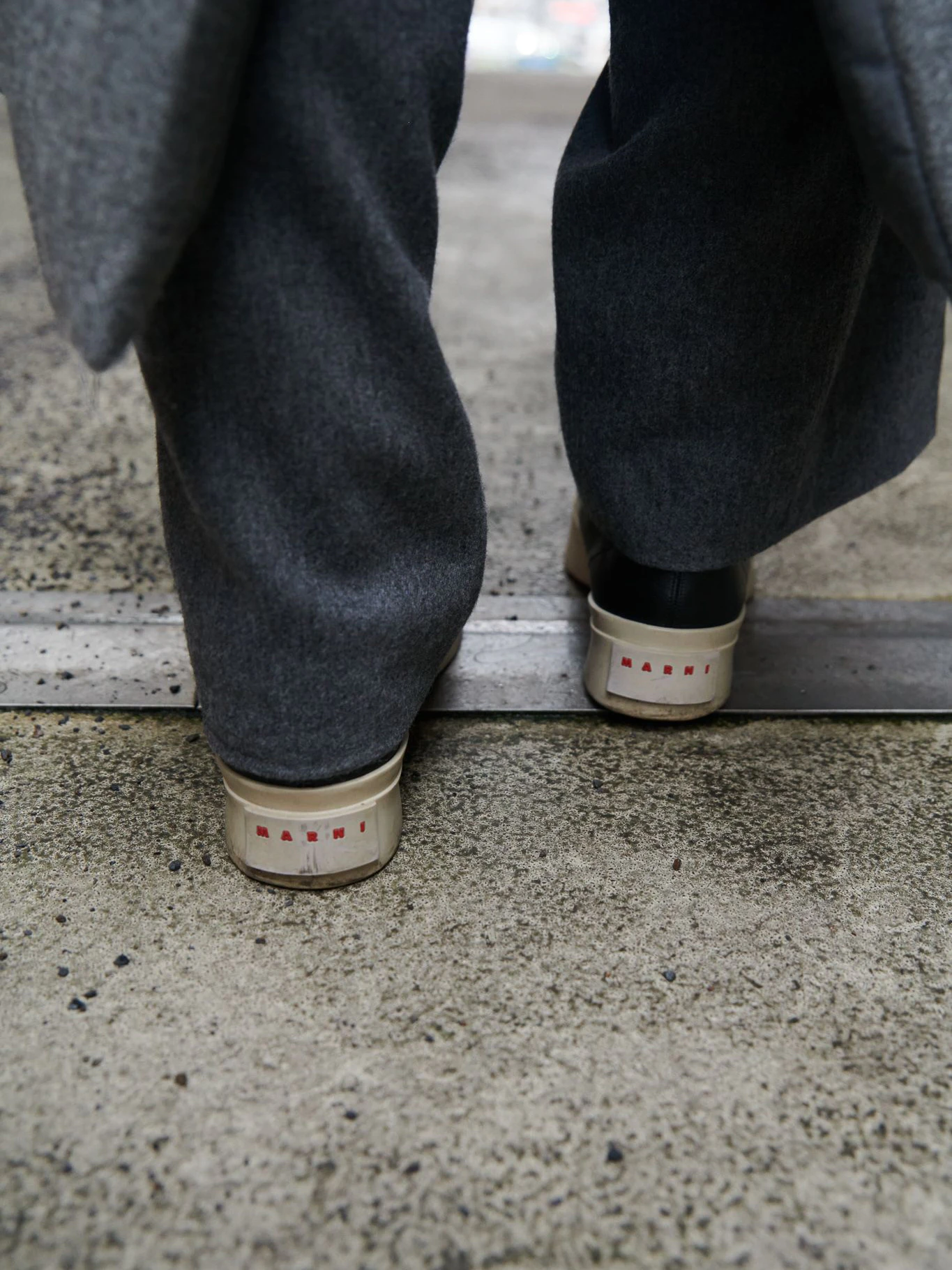 Zu den grau melierten Sandro-Hosen trägt sie schwarze „Pablo“-Ledersneaker von Marni.