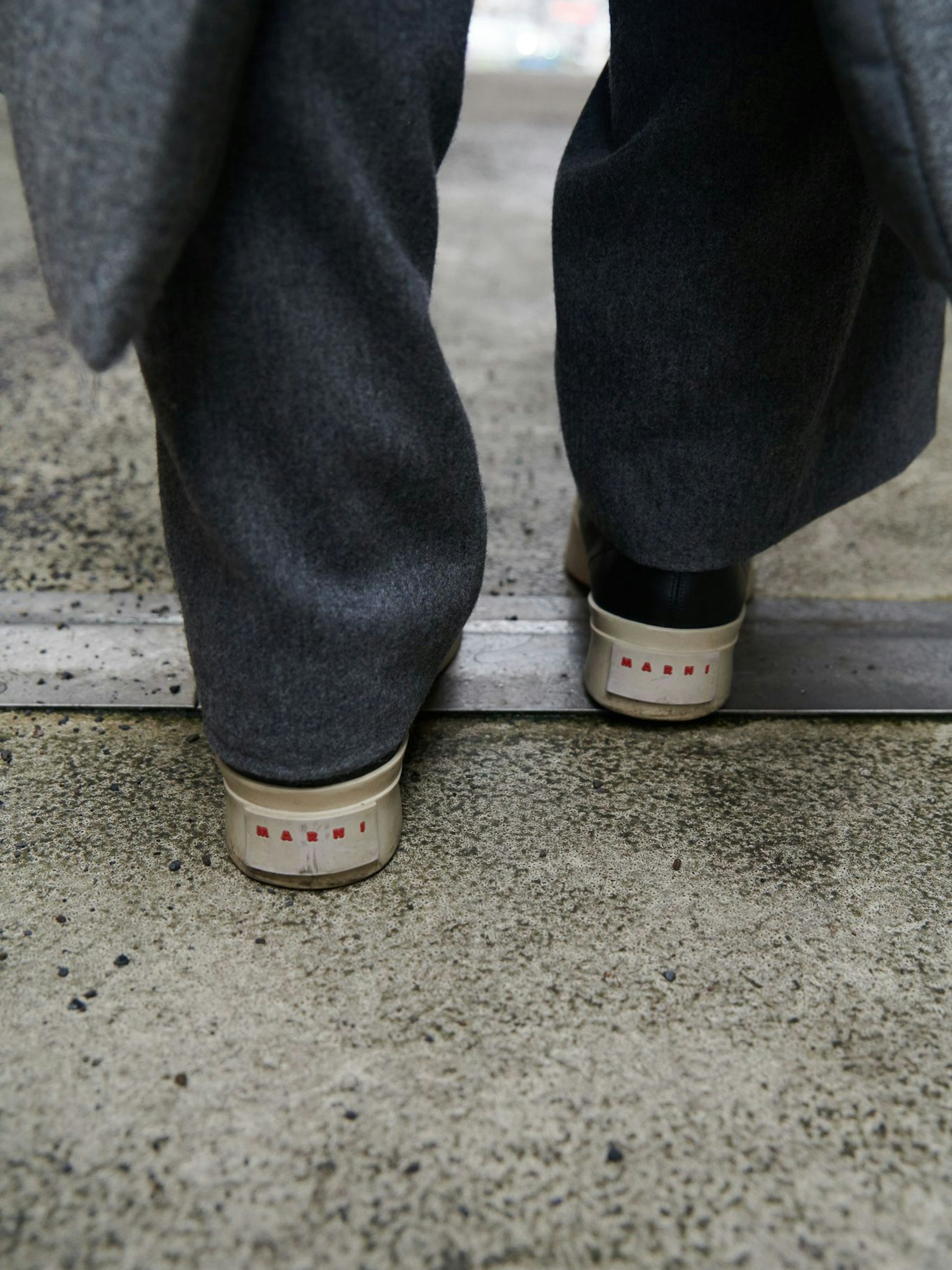 Zu den grau melierten Sandro-Hosen trägt sie schwarze „Pablo“-Ledersneaker von Marni.