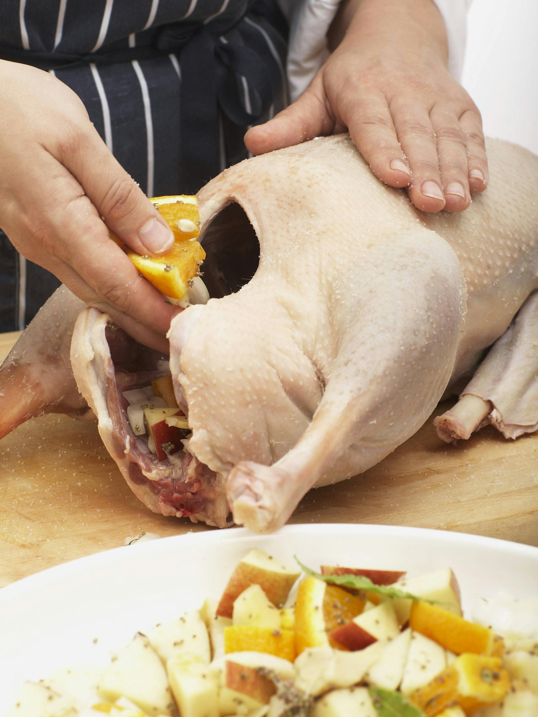 Die Gans mit Äpfeln, Orangen und Majoran füllen.