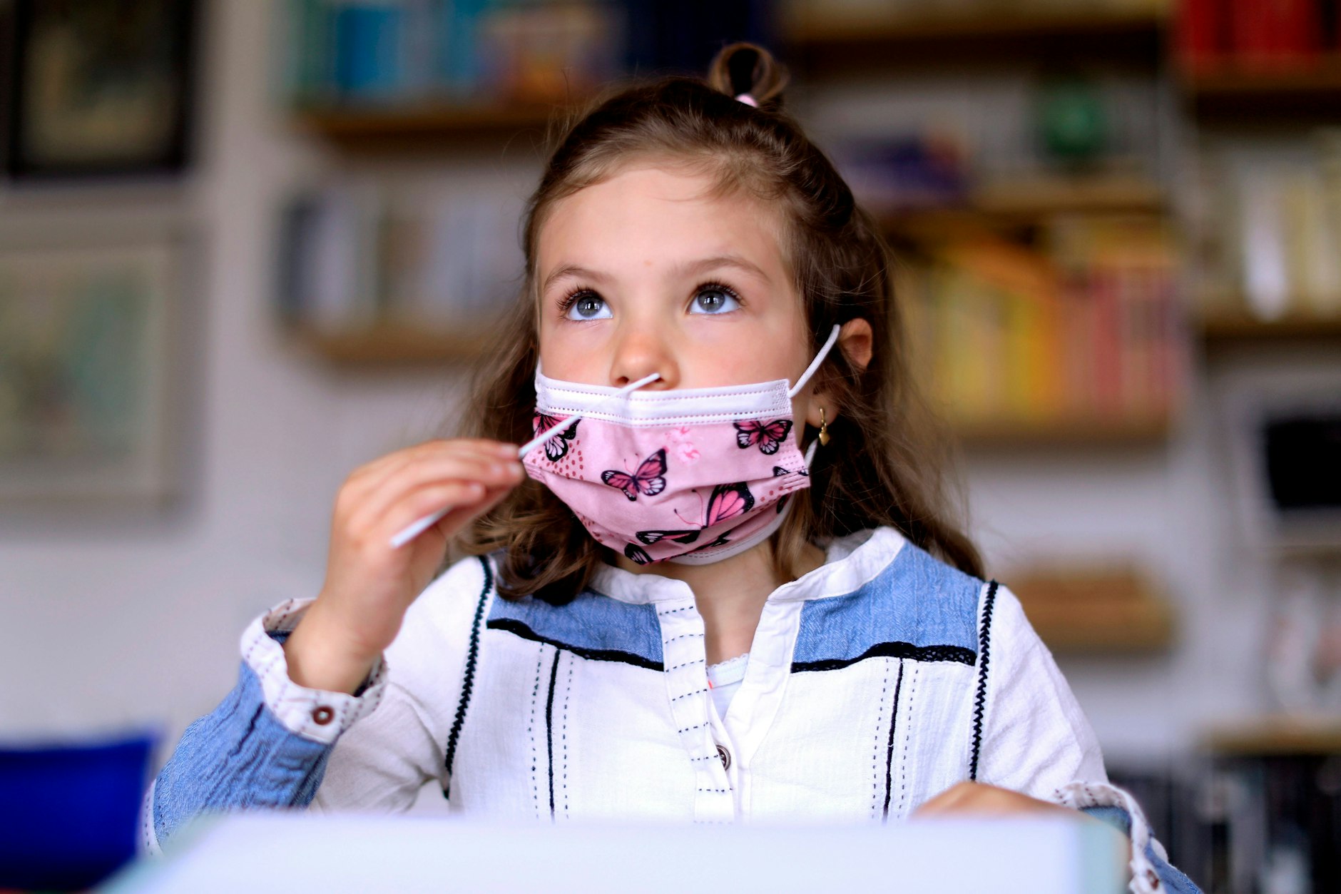 Ein Schulkind mit einem Teststäbchen in der Nase.