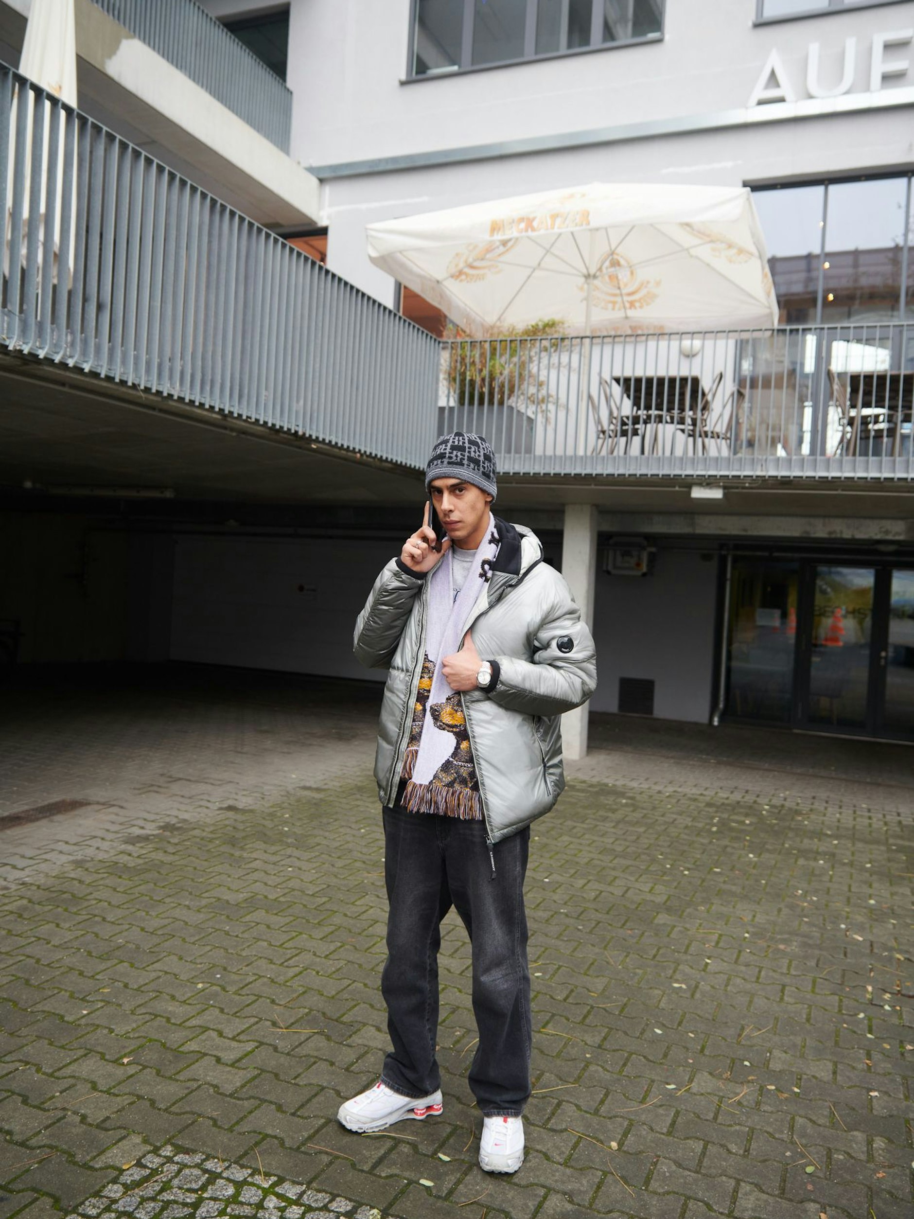 Said ist nicht etwa Rapper, sondern Schmuckdesigner. Hauptsächlich entwirft er Schmuck für Modemarken, zum Beispiel für das Berliner Streetwear-Label Ravani (RVNI). Er trägt eine Jacke von C.P. Company sowie von Ravani: Mütze, Schal, Sweater und Jeans.