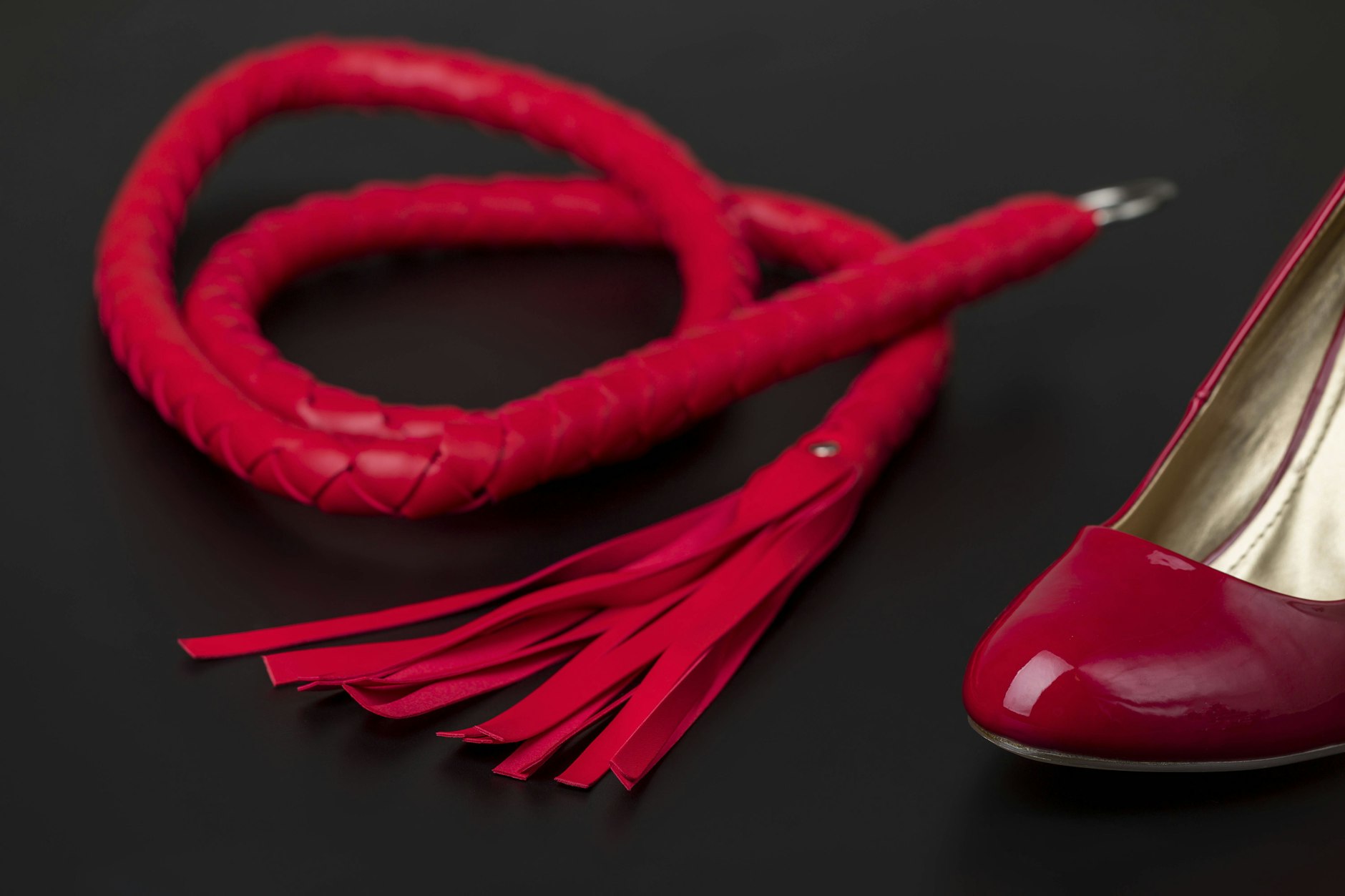 Rote Peitsche und ein High Heel (Symbolbild)