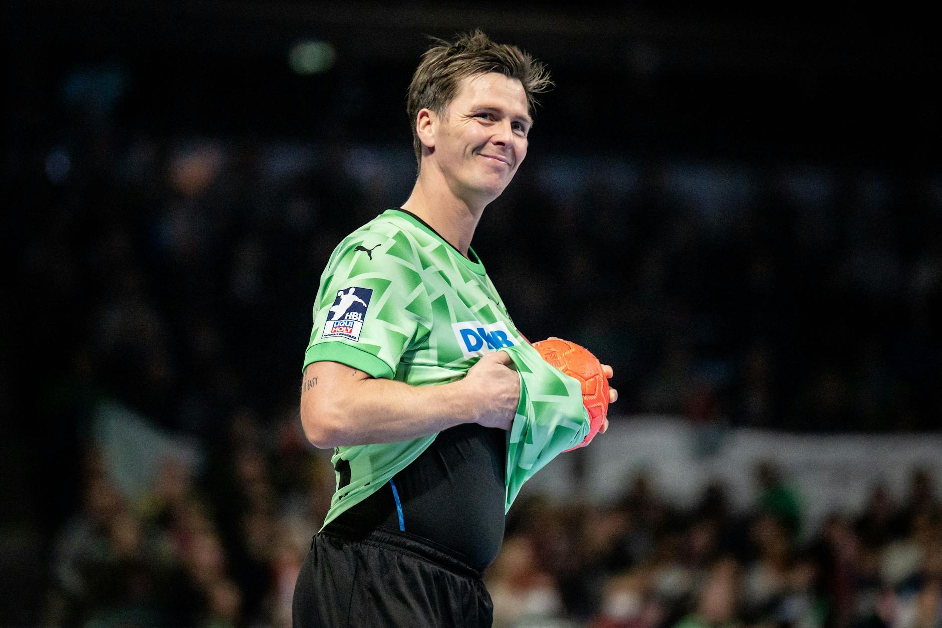 Hans Lindberg wischt mit dem Trikot den Ball sauber.