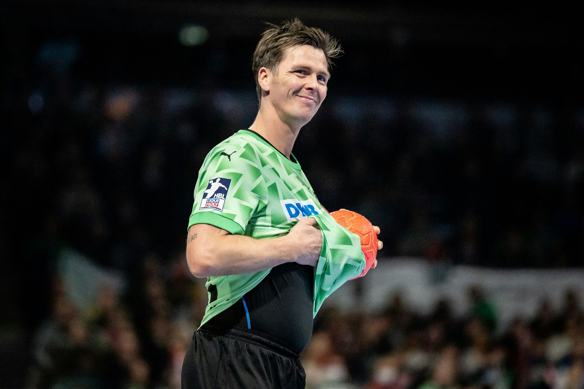 Hans Lindberg wischt mit dem Trikot den Ball sauber.