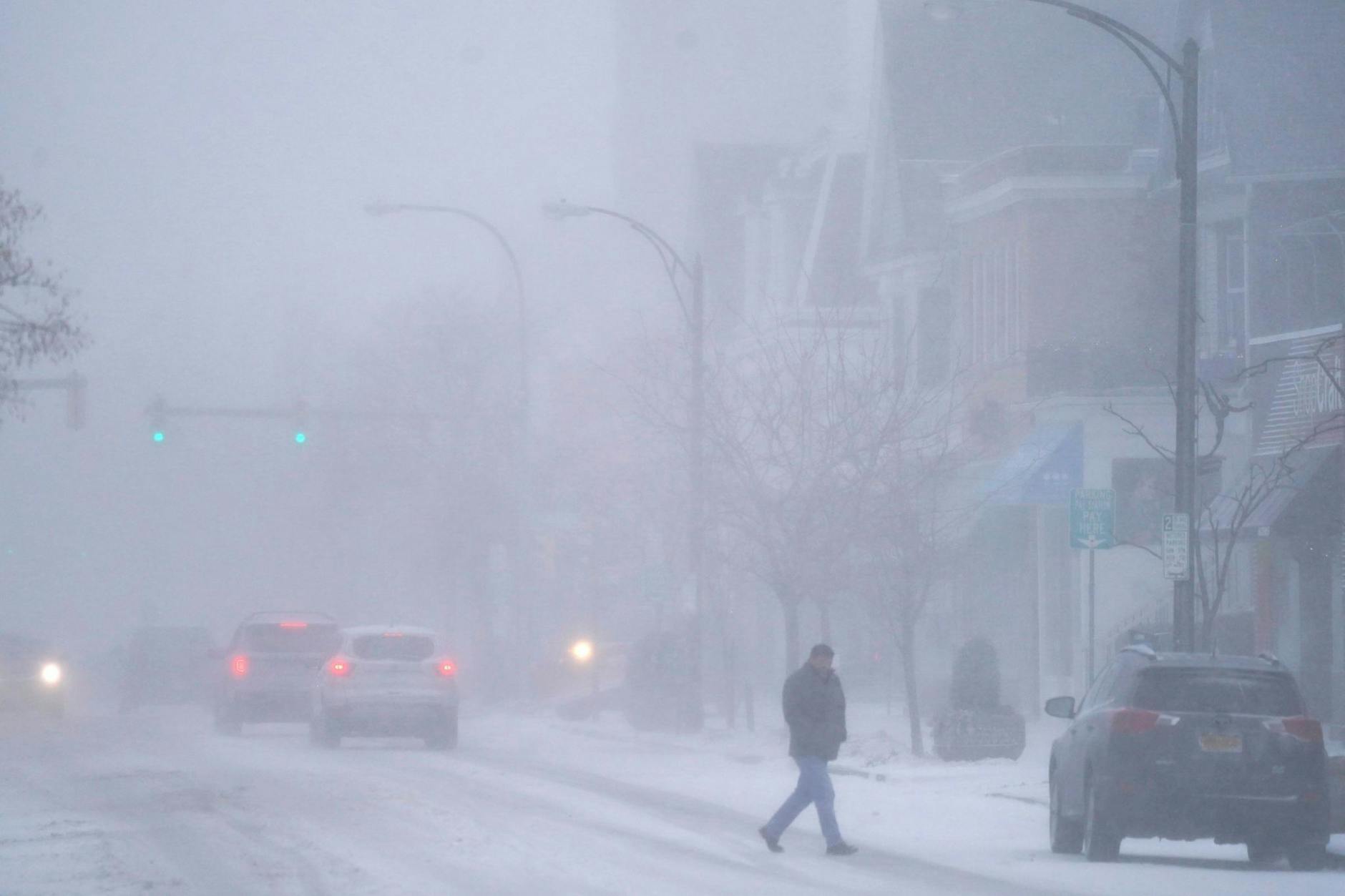 Sicht: extrem eingeschränkt, Temperaturen: im Keller. Ein Fußgänger und wenige Autos sind in Buffalo im Bundesstaat New York unterwegs.