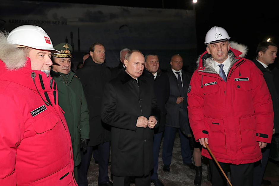 Russlands Verteidigungsminister Sergej Schoigu (2. v. l.), Russlands Präsident Wladimir Putin (M.) und der Generaldirektor der Admiralitätswerft, Alexander Buzakov (r.), besuchen die Admiralitätswerft.