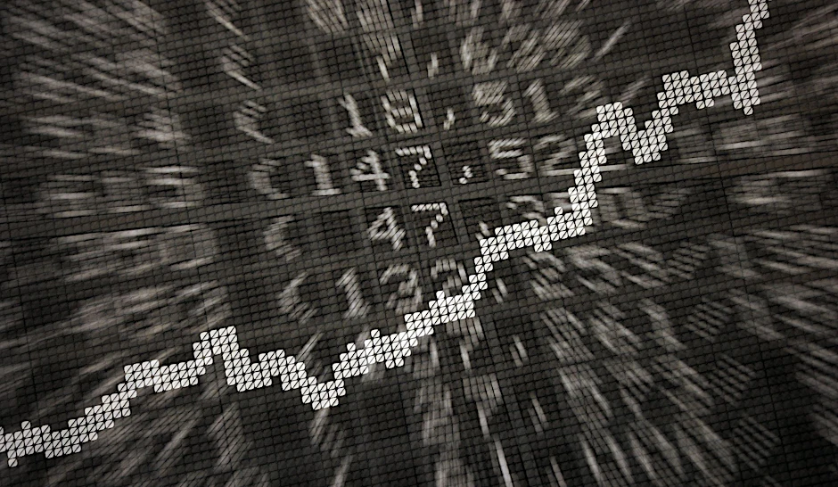 ARCHIV - Die große Anzeige in der Börse zeigt die Dax-Kurve und verschiedene Börsenkurse.  