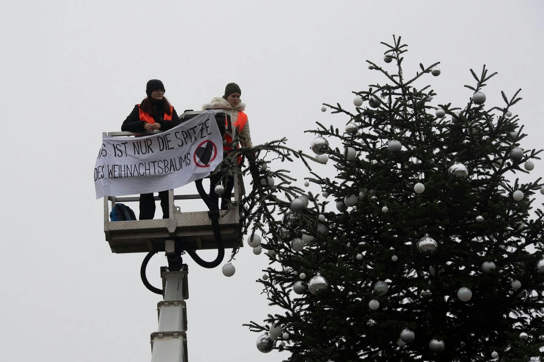Meistens kleben sie sich fest, manchmal sägen sie auch: Klimaaktivisten haben dem Weihnachtsbaum am Brandenburger Tor die Spitze abgetrennt. 