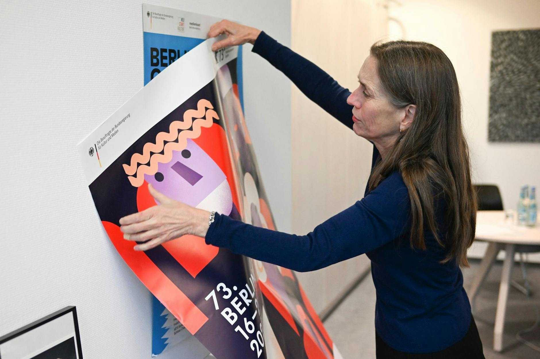 Mariette Rissenbeek, Geschäftsführerin der Berlinale, hängt im Filmfestival-Büro am Potsdamer Platz das neue Berlinale-Plakat auf.