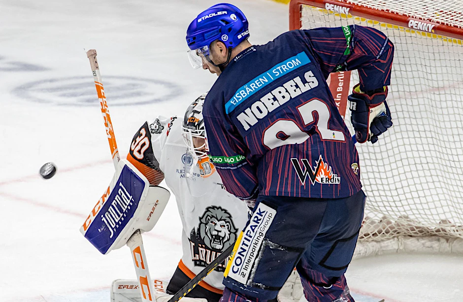 ARCHIV - Ein Torhüter kämpft gegen Berlins Marcel Noebels (r) um den Puck.  