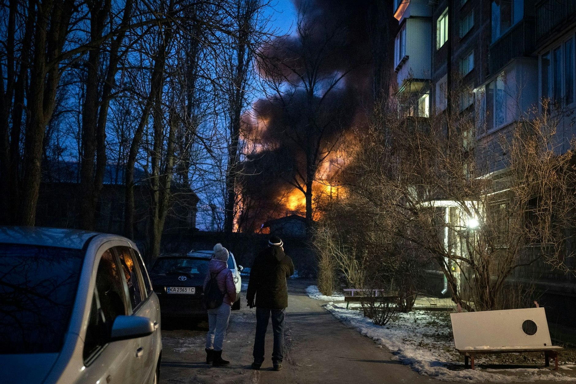 Anwohner beobachten ein brennendes Gebäude in Kiew, das bei einem Drohnenangriff getroffen wurde.