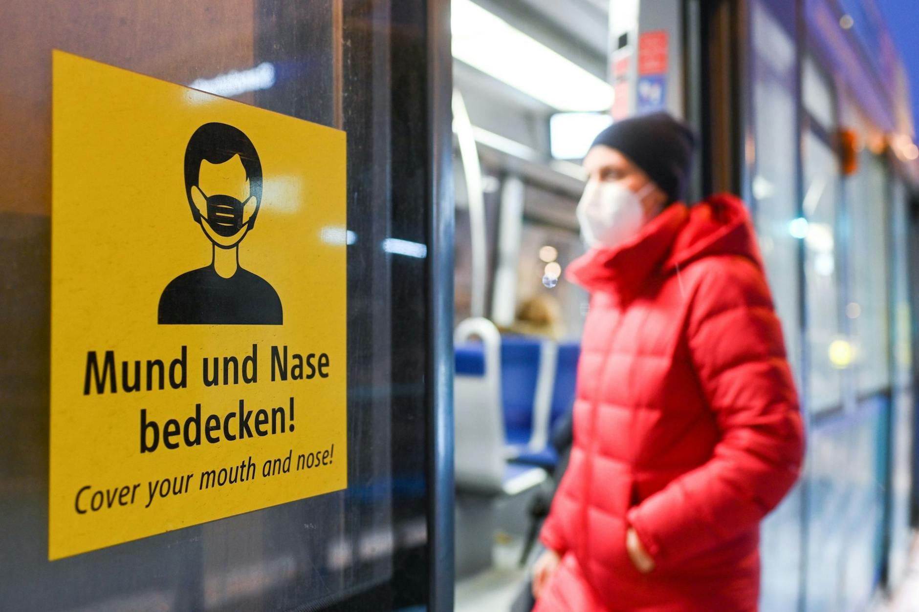 ARCHIV - Eine Frau betritt mit FFP2-Maske eine Trambahn in München.