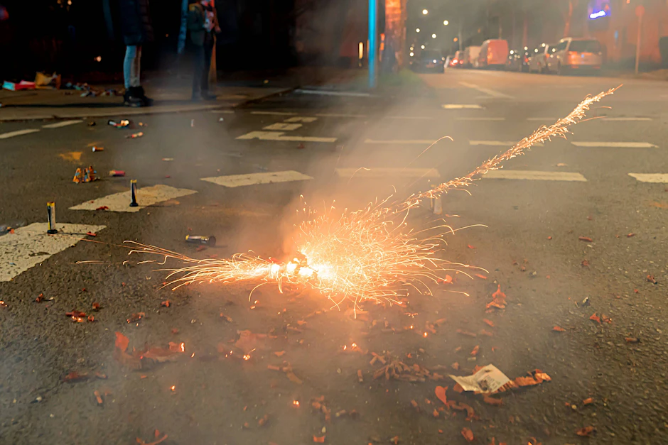 Silvesterböller explodieren auf einer Straße.