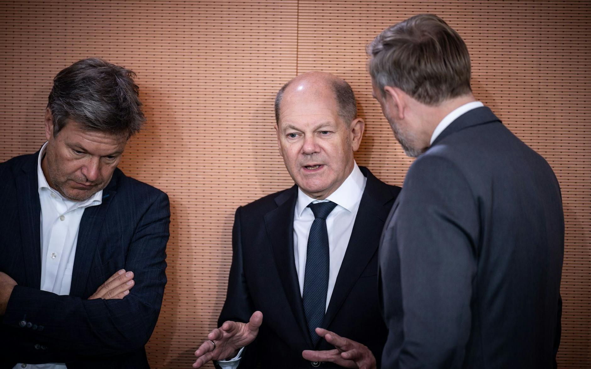 ARCHIV - Kanzler Olaf Scholz (M) spricht mit Finanzminister Christian Lindner (r) und Wirtschaftsminister Robert Habeck.