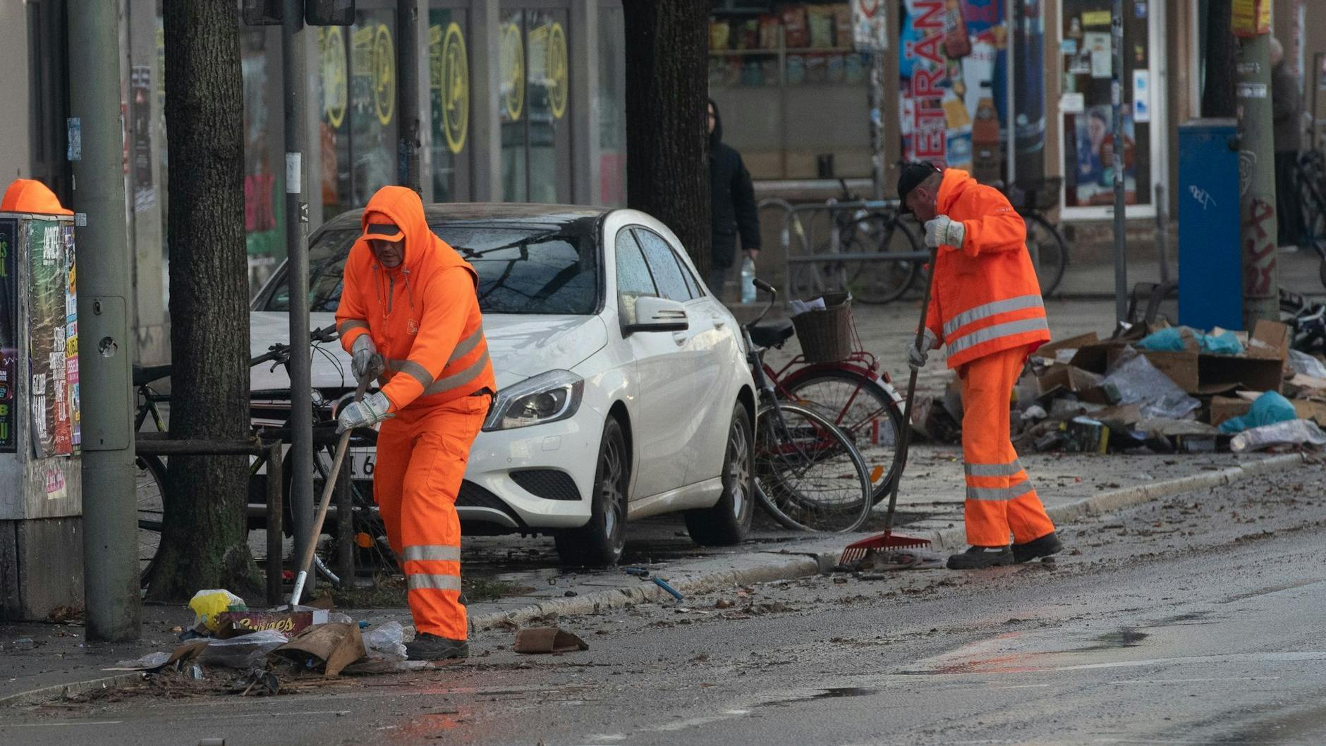 Mitarbeiter der Berliner Stadtreinigung säubern eine Straße von Silvestermüll.