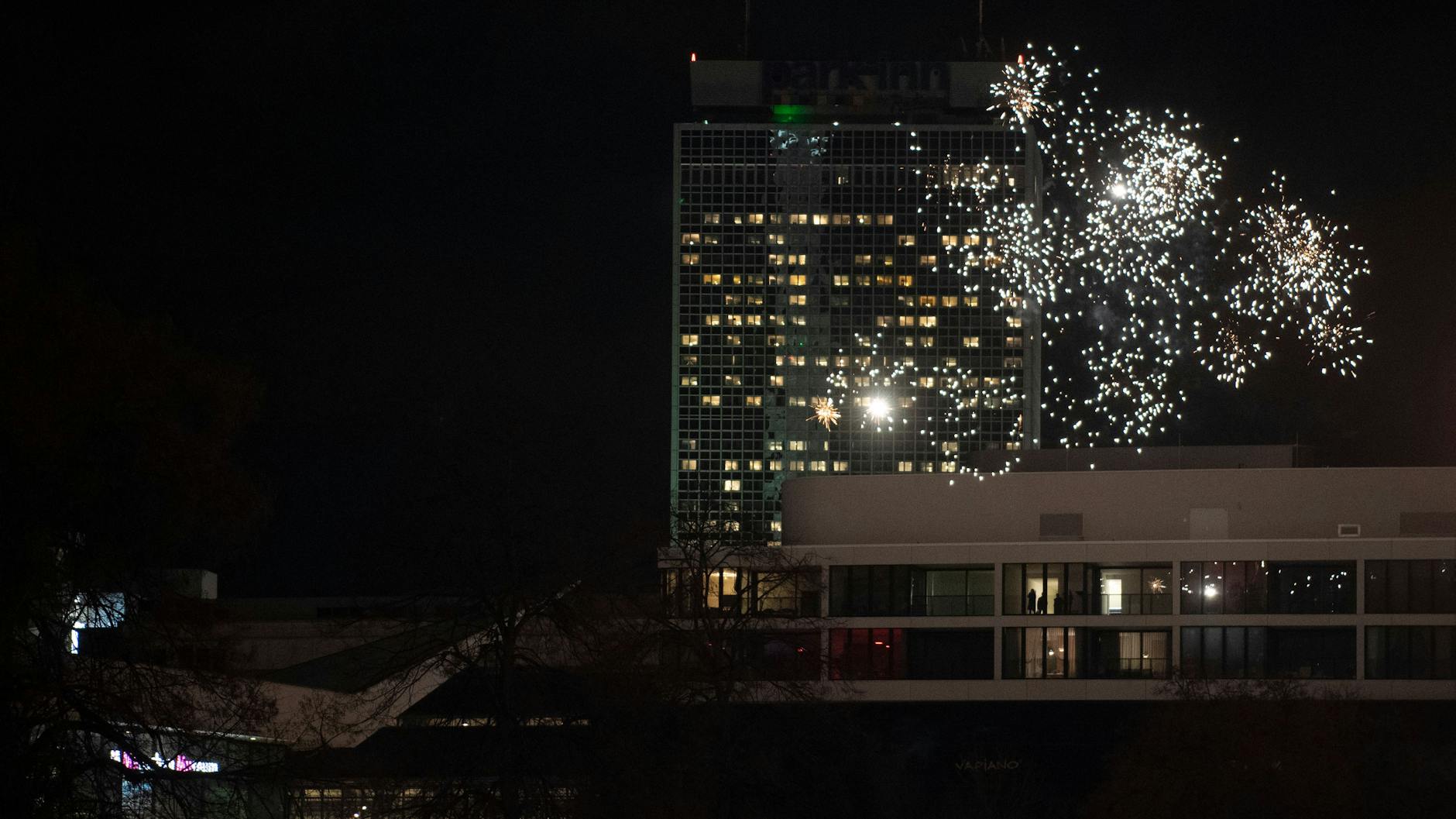 Feuerwerk explodiert am Silvesterabend vor dem Park Inn Hotel am Alexanderplatz.