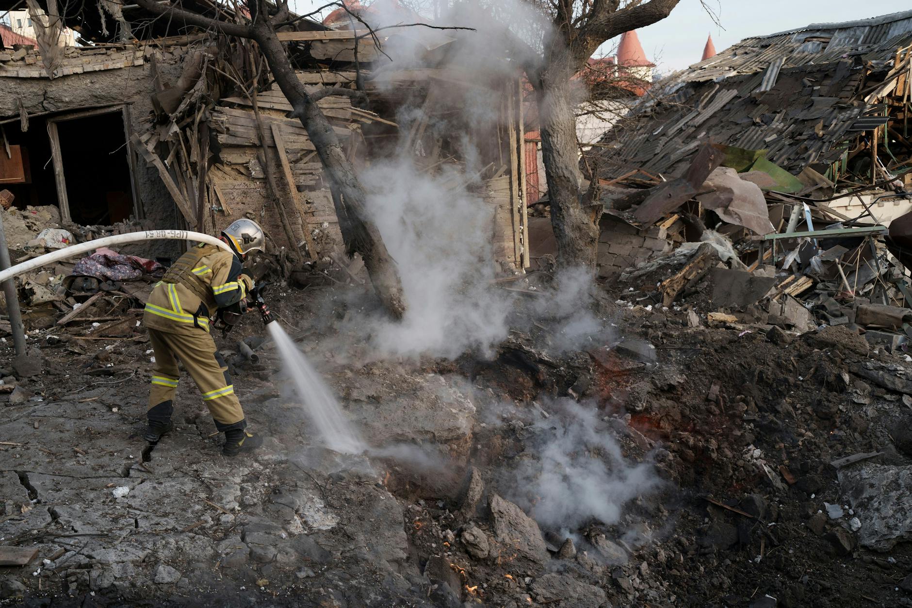 Feuerwehrleute löschen nach einem Beschuss auf die ukrainische Hauptstadt Kiew ein Feuer neben Häusern, die durch die Angriffe zerstört wurden.
