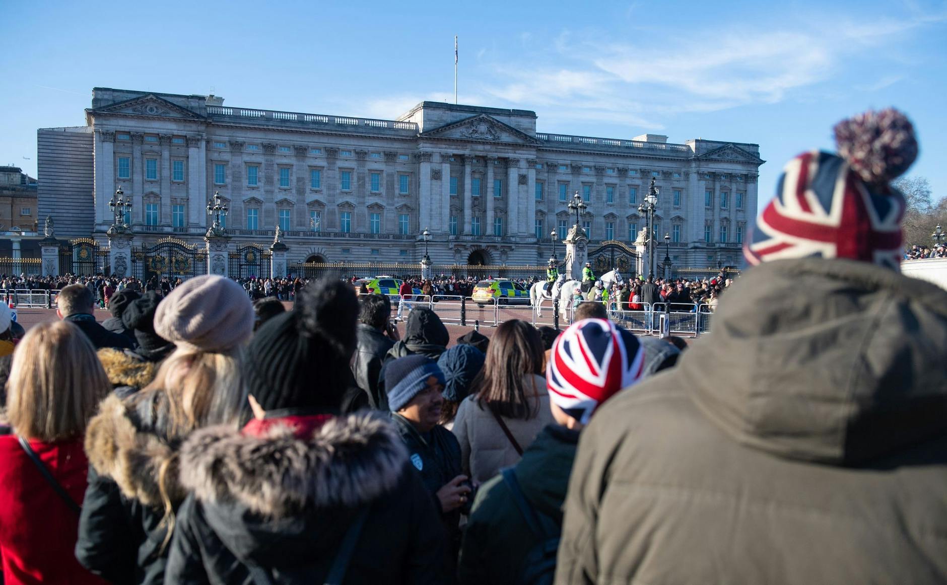 ARCHIV - Touristen beobachten die Wachablösung vor dem Buckingham-Palast. Einer Umfrage zufolge sind 2022 bis Ende des Sommers 83 Prozent weniger Schülerinnen und Schüler aus Europa nach Großbritannien gereist als noch 2019.