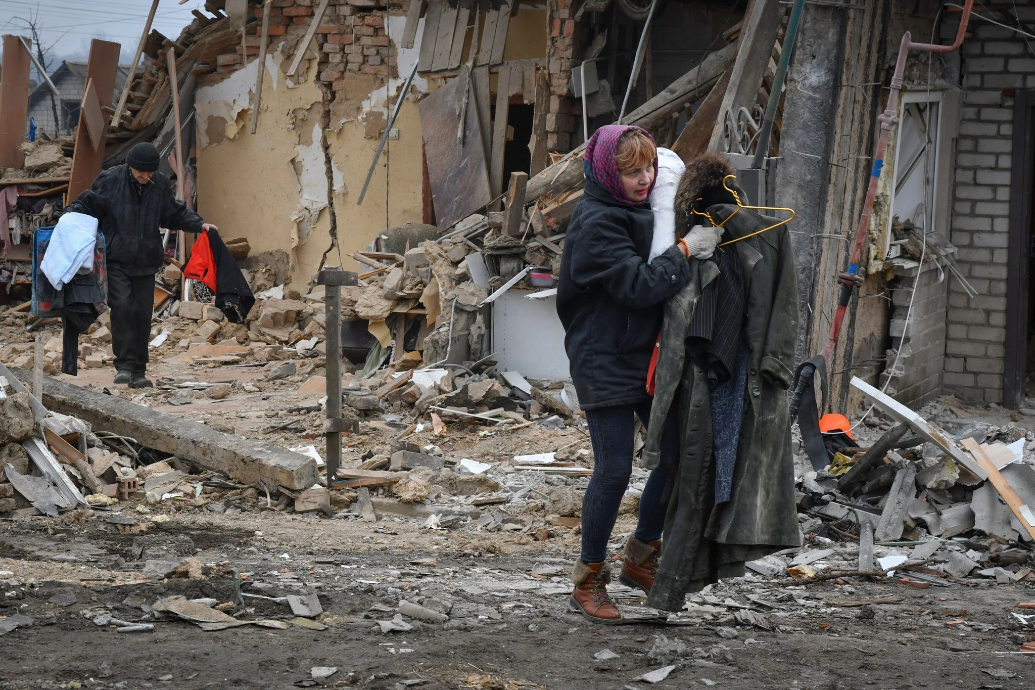 Anwohner tragen ihre Habseligkeiten aus von Bomben zerstörten Häusern.