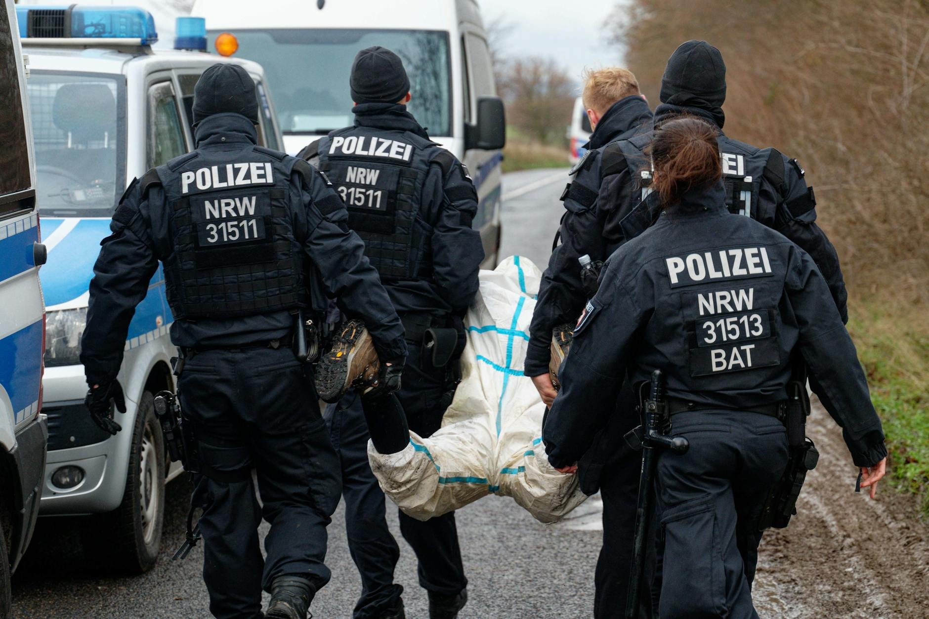 Polizisten tragen eine Aktivistin zur Überprüfung ihrer Personalien. 