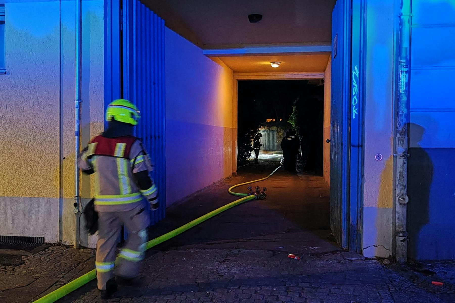 Die Berliner Feuerwehr löscht den Mülltonnen-Brand in einem Neuköllner Hinterhof.