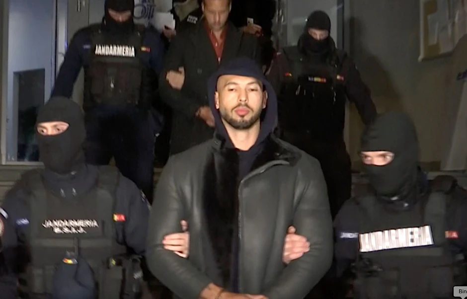 Andrew Tate (M.) bei seiner Festnahme durch die rumänische Polizei.